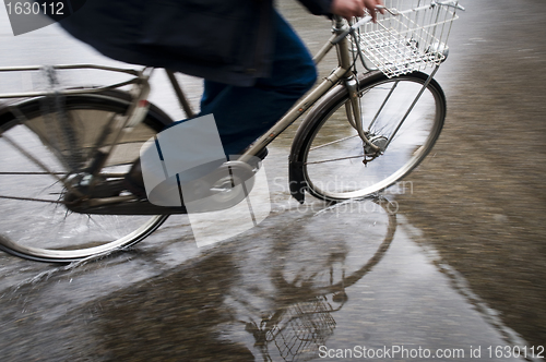 Image of Man on bicycle in puddle