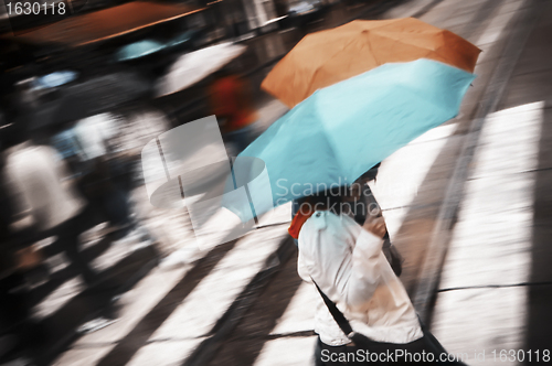 Image of Two women under umbrella crossing