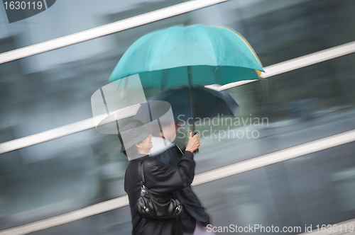 Image of Two women under umbrella in rain