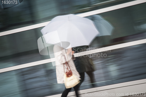 Image of Woman under umbrella in rain