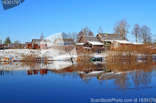 Image of boats near villages on coast river 