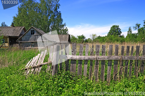 Image of old fence near rural wooden building