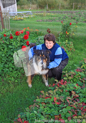 Image of woman with dog amongst flowerses