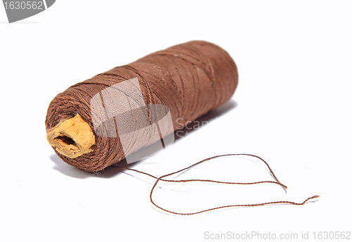 Image of spool  brown threads on white background