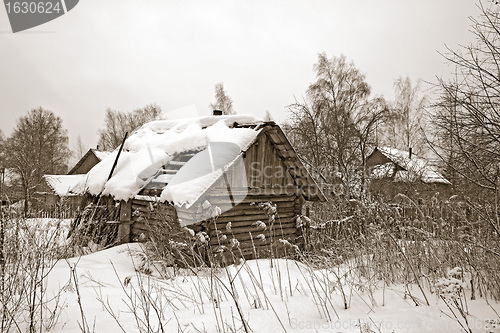 Image of old wooden house amongst winter snow