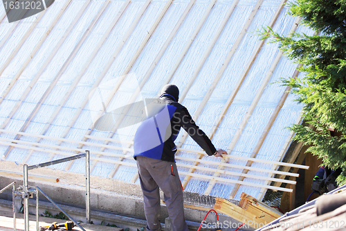 Image of roofer working on a new roof in wood