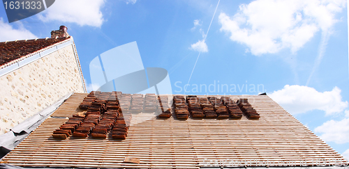 Image of renovation of a tiled roof of an old house