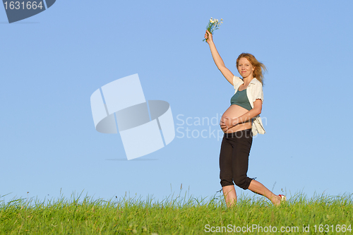 Image of pregnant woman on meadow