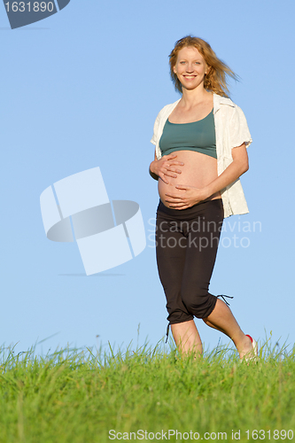 Image of pregnant woman on meadow