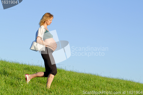 Image of pregnant woman on meadow