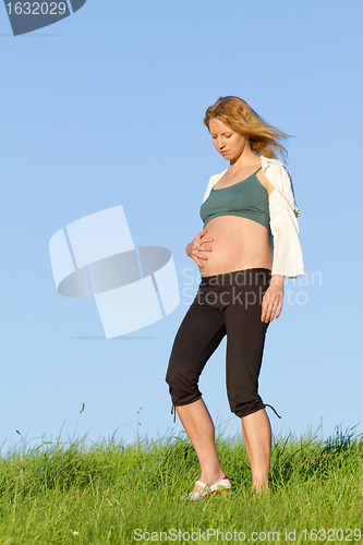 Image of pregnant woman on meadow