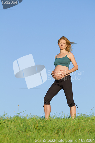 Image of pregnant woman on meadow