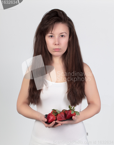Image of The young beautiful woman with the fresh strawberries