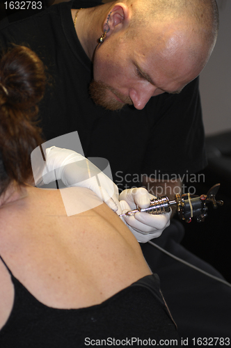 Image of a man tattooing