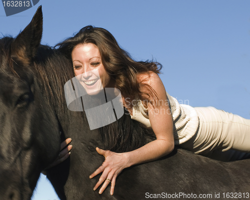 Image of laughing woman and stallion