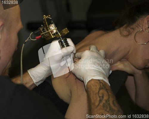 Image of a man tattooing a woman