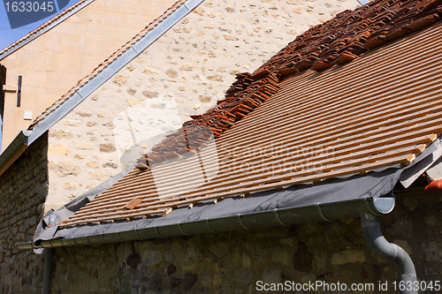 Image of renovation of a tiled roof of an old house