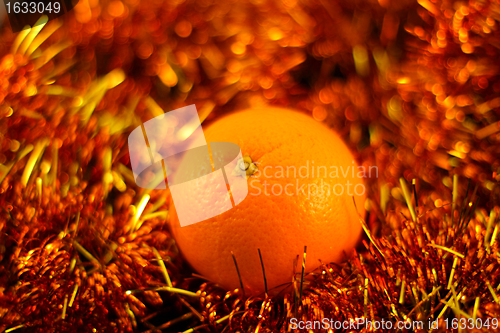 Image of orange close up on a background of twinkling garlands