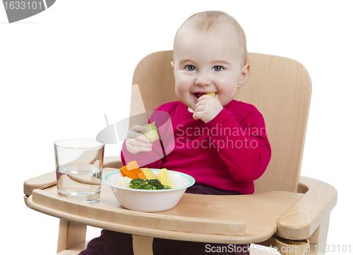 Image of young child eating in high chair