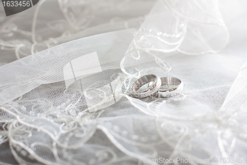 Image of ring of white gold are on the bride's veil