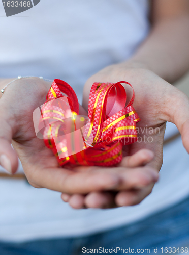 Image of young woman holds a gift bow in hands