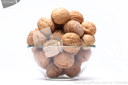 Image of Walnuts lie in a glass bowl isolated on white