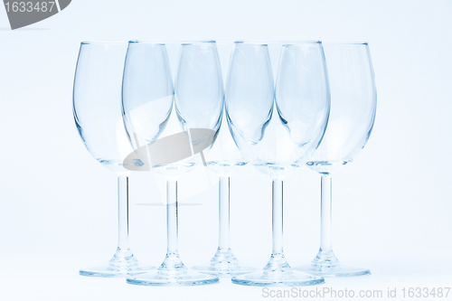 Image of Empty wine glasses stand symmetrically on white