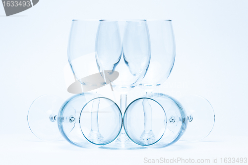 Image of Empty wine glasses stand and lie symmetrically