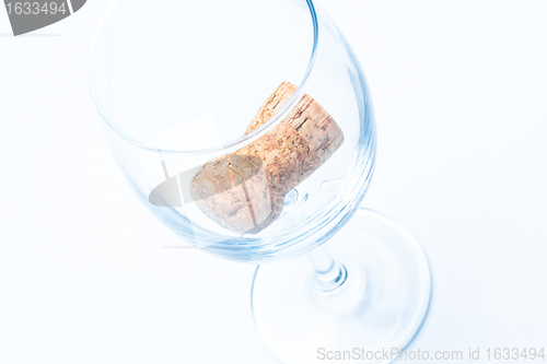 Image of single glass of wine with cork from a bottle