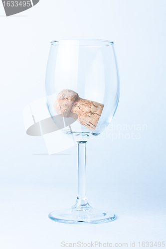 Image of single glass of wine with cork from a bottle