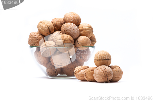 Image of Walnuts lie in a glass bowl isolated on white