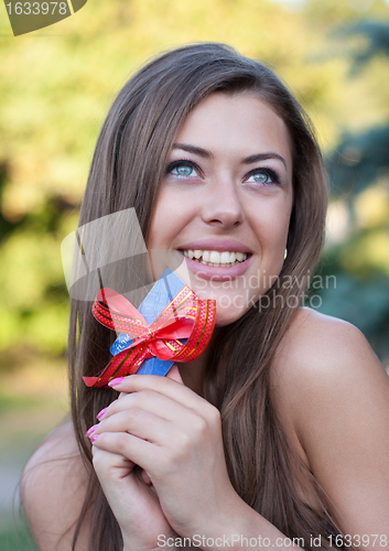 Image of happy young woman holds credit card in hands