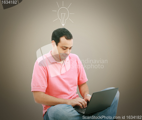 Image of Man using a laptop with light bulb over his head
