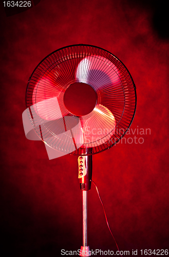 Image of office fan on dark red background