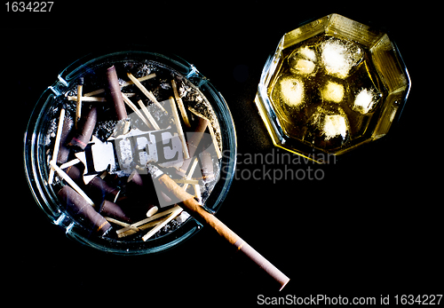 Image of ashtray full of butts and glass of whiskey