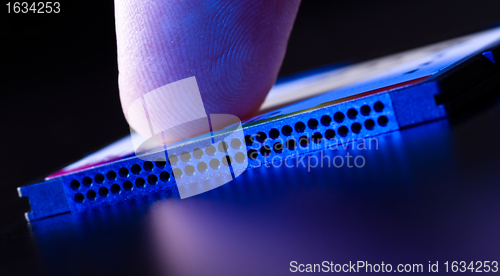 Image of finger on flash card in blue light closeup