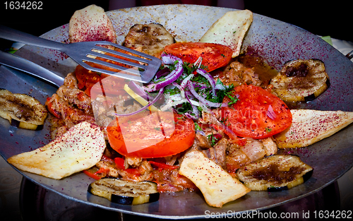 Image of metal dish with fried meat and vegetables