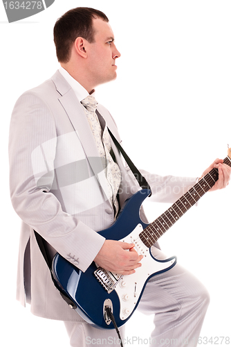 Image of man in grey suit playing guitar