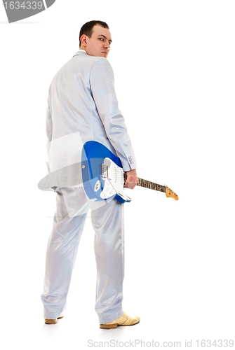 Image of man in white suit with electric guitar look back