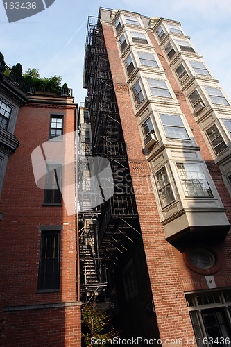 Image of Tall building with fire escape and bay windows full color