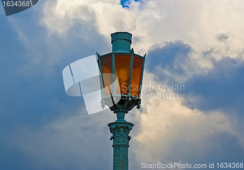 Image of vintage street lamp on cloud sky background