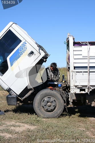 Image of Man repairing a broken truck