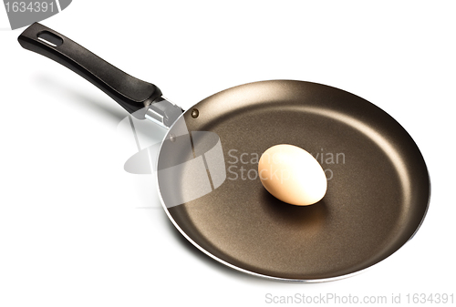 Image of brown raw egg on frying pan