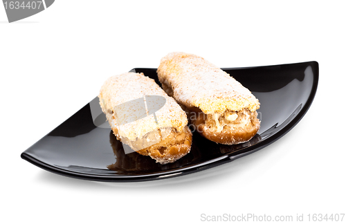 Image of two eclairs on black dish