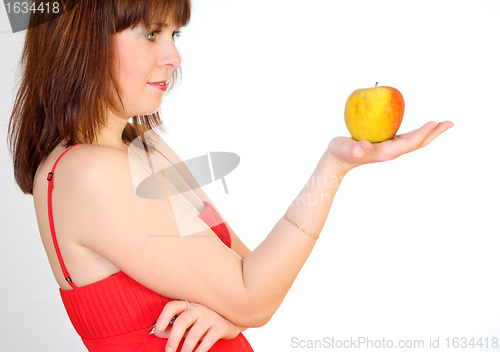 Image of beautiful girl with apple on palm
