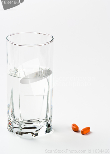 Image of two pills and glass of water