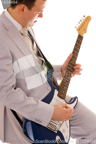 Image of man in white suit playing guitar