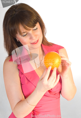 Image of beautiful girl with orange in hands