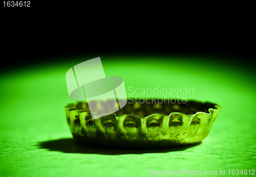 Image of beer cap closeup on green