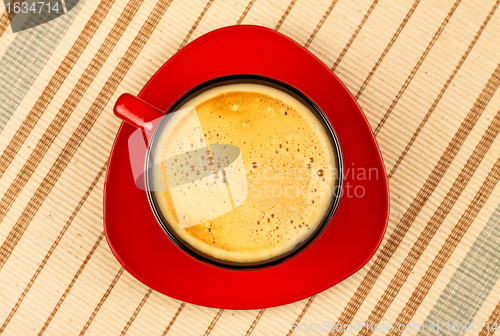 Image of red coffee cup on striped tablecloth